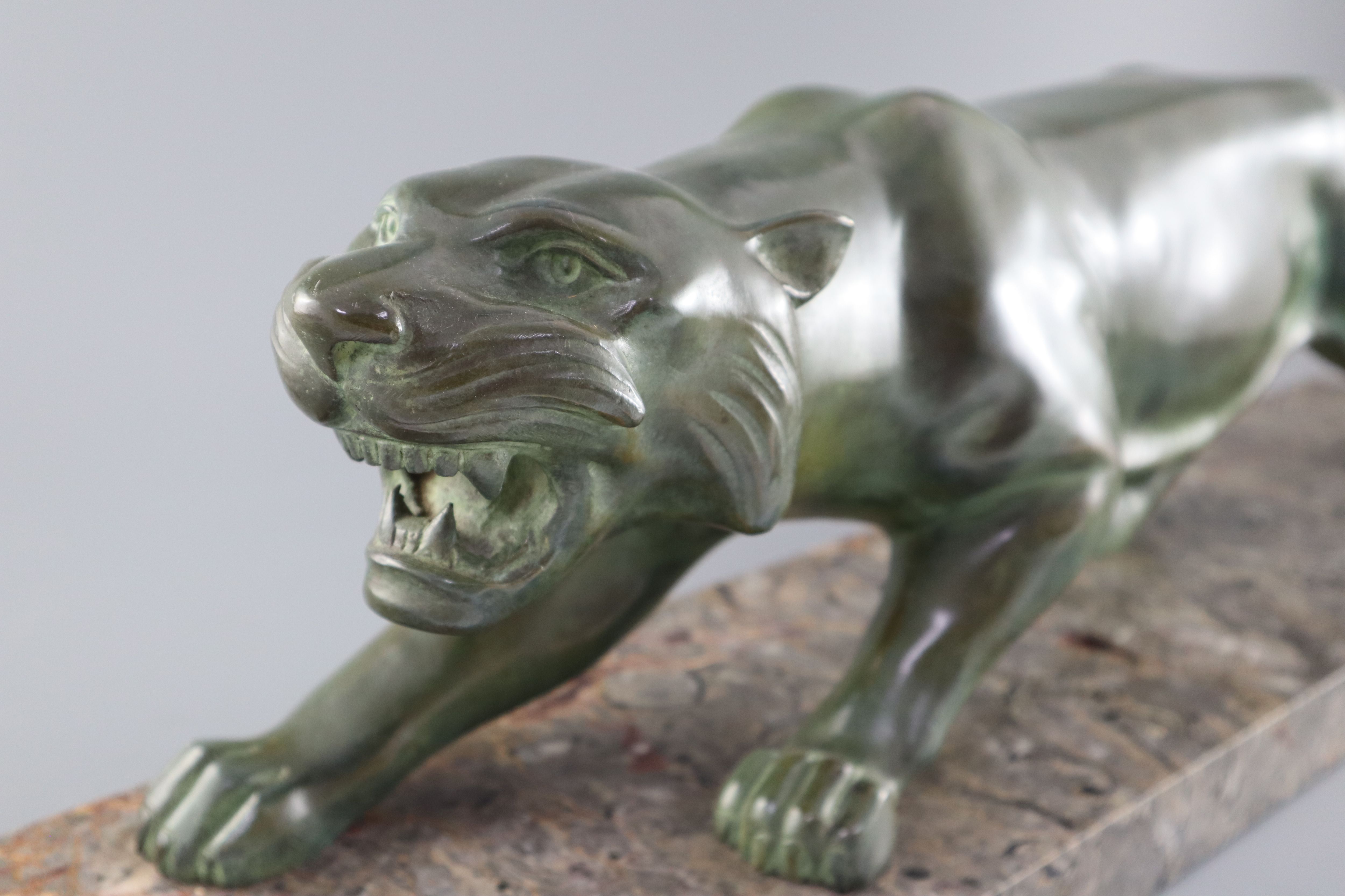 Brault. An Art Deco patinated bronze model of a prowling panther, width 29.5in. height 8.5in.